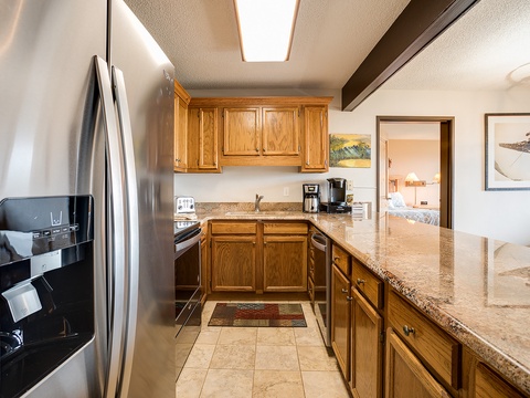 Your fully equipped kitchen invites you to prepare meals with ease, featuring modern appliances, warm oak cabinetry, and gleaming granite countertops—perfect for morning coffee or home-cooked dinners.
