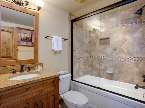 Refresh after your mountain adventures in this beautifully tiled bathroom, featuring a deep soaking tub and shower combo with elegant mosaic accents.