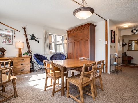 Gather around the sturdy wooden dining table and enjoy meals together in this bright, ski-themed retreat. Natural light fills the space, highlighting rustic mountain touches and vintage ski decor throughout.