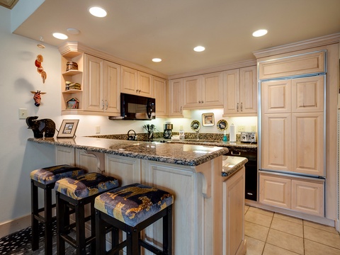 A fully equipped kitchen awaits with granite counters, modern appliances, and a cozy breakfast bar where you can sip coffee and plan your day.