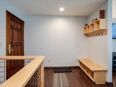 Your private entryway features custom storage shelves and hooks to keep your belongings organized, with warm wood accents creating a welcoming first impression as you arrive.