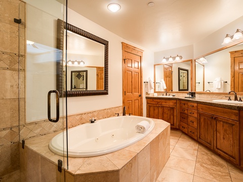 Indulge in your private spa-like retreat with a deep soaking tub, dual vanities, and a spacious walk-in shower—perfect for unwinding after mountain adventures.