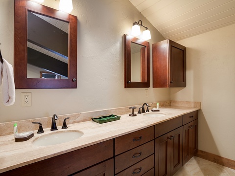 Your well-appointed dual-sink vanity offers ample space for morning routines, with elegant cabinetry, warm lighting, and polished countertops ready for your stay.