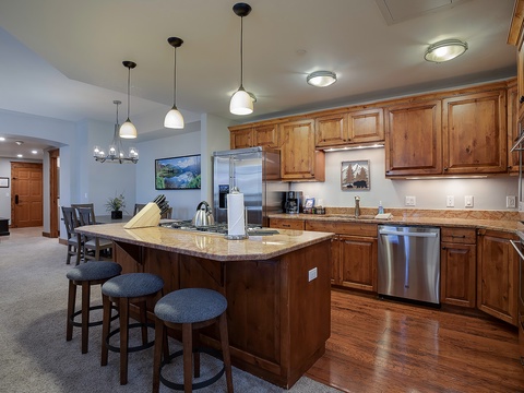 Step into your spacious gourmet kitchen with rich wood cabinetry, granite countertops, and stainless steel appliances—perfect for preparing meals together after a day of mountain adventures.