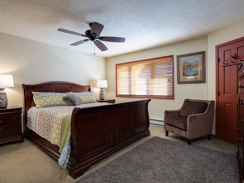 Settle into your cozy bedroom with elegant dark wood furnishings, plush bedding, and a peaceful reading nook—your restful retreat after a day of adventure.