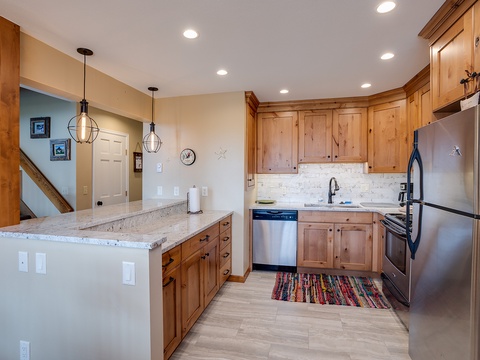 Your spacious mountain kitchen awaits with warm wood cabinetry, granite countertops, and modern stainless-steel appliances—everything you need to craft memorable meals together.
