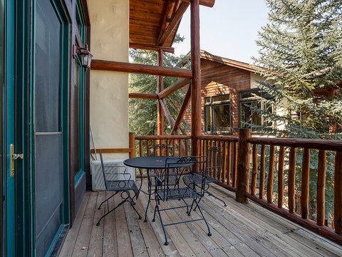 A covered deck nestled among the trees, perfect for your morning coffee or evening relaxation surrounded by nature's tranquility.
