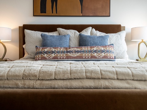 Sink into plush bedding and let soft lighting set the mood for restful sleep. Textured pillows and thoughtful decor make this your personal retreat.
