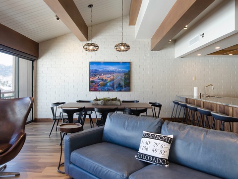 Gather in your open-concept living space featuring exposed beams, modern lighting, and Steamboat coordinates—designed for making memories with family and friends.