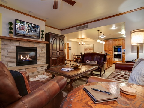 Sink into plush leather seating by the warm stone fireplace, enjoy your favorite shows, and take in the seamless flow into a fully equipped kitchen—your perfect retreat awaits.