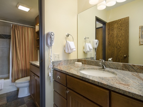 Freshen up in your spacious bathroom with granite counters, well-lit vanity, and fluffy towels at your fingertips. Just beyond, a sleek tiled shower awaits your relaxation.