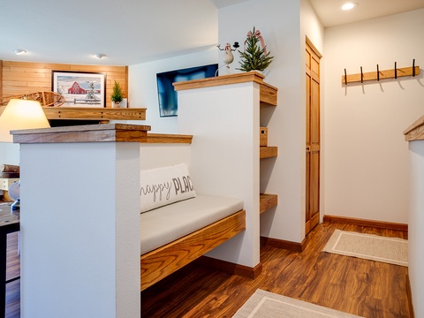 Step into your cozy retreat with warm wood accents, built-in benches, and thoughtful storage hooks welcoming you home after your mountain adventures.