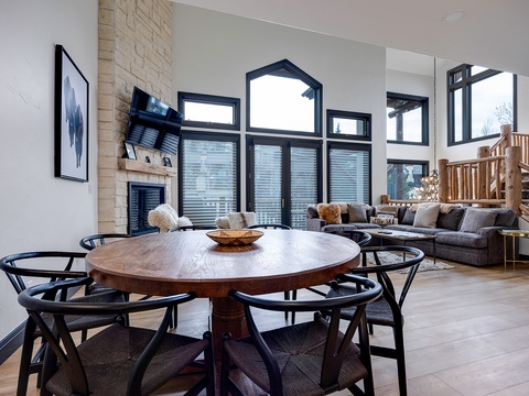 Gather around this handsome round dining table with seating for six, bathed in natural light from soaring windows. The cozy living area and fireplace invite you to relax after a day of exploration.