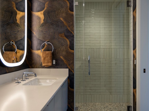 Step into your private spa-like retreat with sleek subway tile, a spacious glass-enclosed shower, and artful wall accents that add warmth and character to your daily routine.