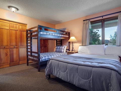 Your spacious retreat blends comfort and flexibility with a plush king bed, cozy bunk beds for the kids, and mountain views framed by your private window—perfect for family getaways.