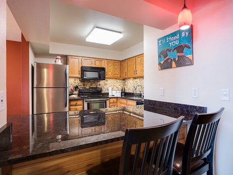 Your fully-equipped kitchen features sleek granite countertops, stainless appliances, and a stylish breakfast bar—perfect for whipping up meals and gathering over morning coffee.