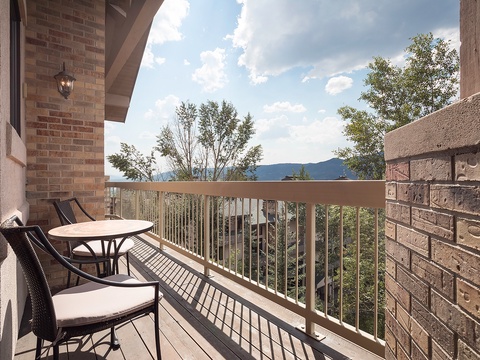 Sip your morning coffee on your private balcony while soaking in stunning mountain vistas framed by lush trees and bright blue skies.
