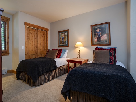 Two cozy beds await your group in this charming room, accented with warm wood tones, western-inspired art, and soft lighting for a restful mountain retreat.