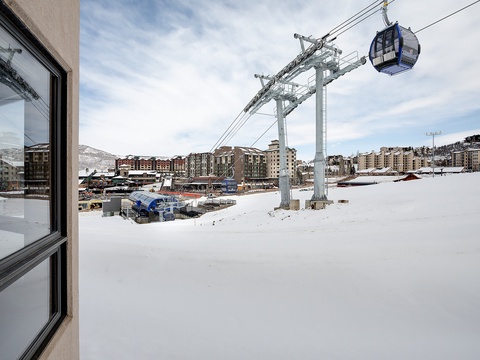 Ski resort village with gondola access and mountain views, situated in a winter alpine setting with snow-covered terrain and surrounding lodges.