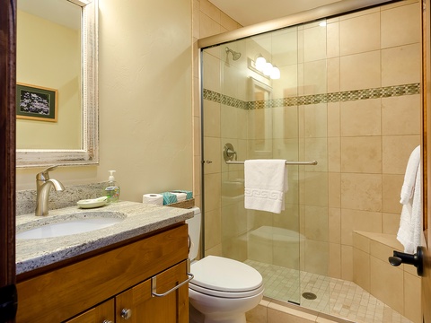 Freshen up in your private bathroom featuring a spacious walk-in shower, elegant tilework, and a granite vanity with all the comforts you need.