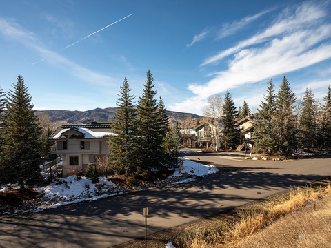 A peaceful mountain neighborhood with tree-lined streets and stunning views of the surrounding peaks, offering a serene natural setting for the property.