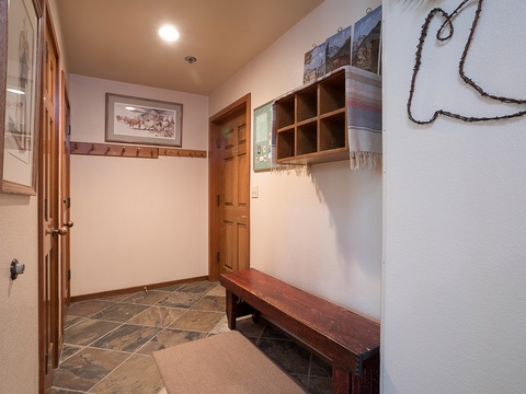 Cozy entryway with rustic charm greets you upon arrival, featuring stone tile flooring, wooden accents, and cubbies for your gear and belongings.