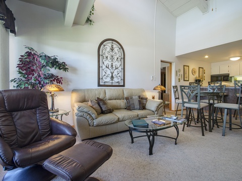 Settle into your cozy living space with plush seating, cathedral ceilings, and an open flow into the dining area and fully equipped kitchen—perfect for relaxing together after a day of mountain adventures.