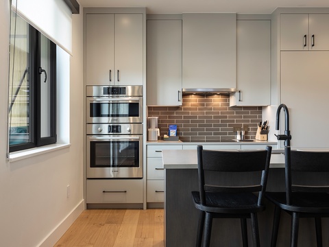 Your modern kitchen awaits, fully equipped with stainless steel appliances and a sleek breakfast bar—perfect for whipping up morning coffee or sharing evening meals together.
