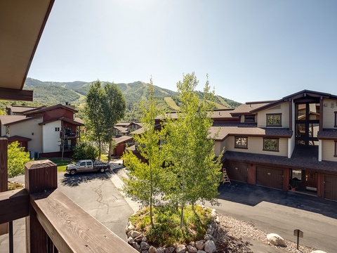 A scenic mountain community nestled against rolling peaks, offering easy access to nearby homes and parking for convenient arrivals and departures.