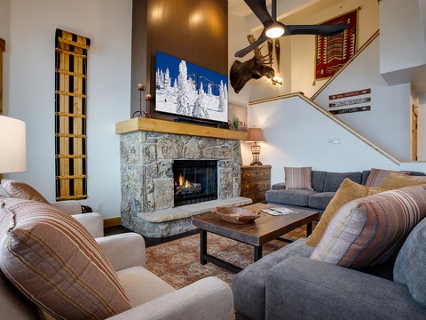 Cozy up in your spacious living room with vaulted ceilings, a crackling stone fireplace, and mountain charm. Plush seating invites you to relax after a day on the slopes, while rustic touches create a warm, alpine retreat.
