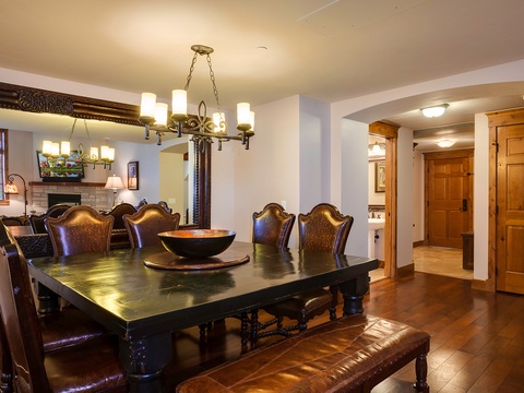 Gather around this elegant dining table for memorable meals with your group. Rich wood tones and leather seating create a warm, inviting space where you'll share stories over home-cooked favorites.