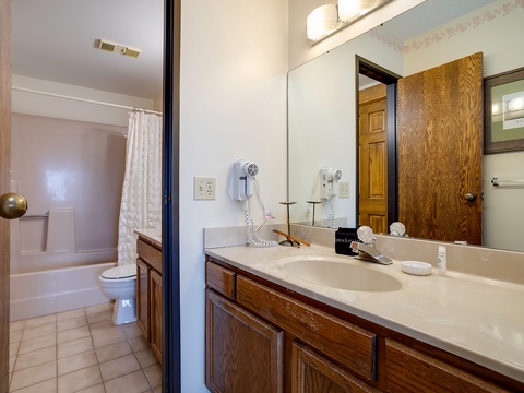 Your private bathroom features a spacious vanity with ample counter space, convenient hair dryer, and a separate room with shower-tub combo for your comfort.