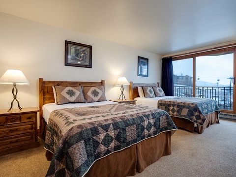 Wake up to stunning mountain views from your cozy bedroom. Two comfortable beds, warm wood furnishings, and soft lighting create the perfect alpine retreat after a day of adventure.