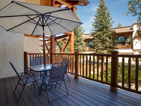 Your private deck overlooking pine-lined grounds, complete with shaded dining for sunny alpine mornings and peaceful evenings under the mountain sky.