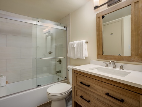 Step into your private bathroom where fresh towels await and a glass-enclosed tub invites you to unwind after a day of adventure.