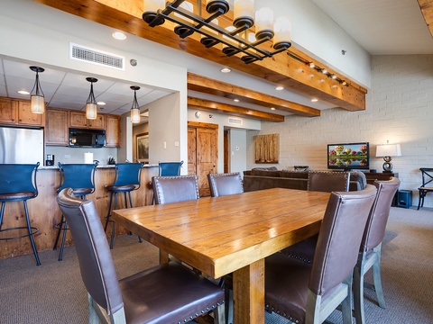 Gather around your spacious dining table beneath rustic beams, with a fully equipped kitchen and cozy living area creating the perfect open space for memorable evenings together.