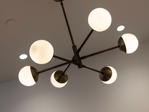 A striking modern chandelier with glowing orb lights sets a sophisticated mood in your space, blending contemporary design with warm, inviting ambiance.