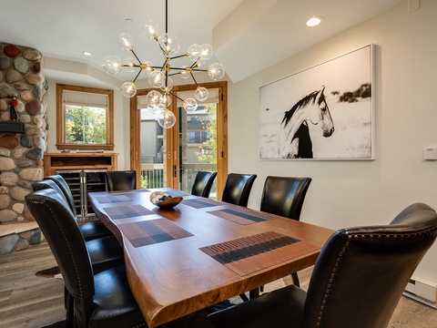 Gather around this handsome dining table, where a statement chandelier sets the mood for memorable meals with your group beneath vaulted ceilings and natural light.