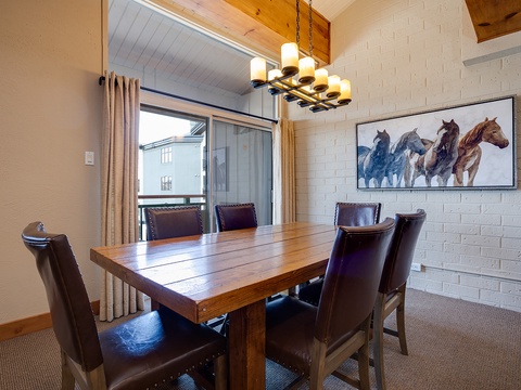Gather around this handsome wooden table under warm lighting, where laughter flows as easily as conversation. The rustic chandelier and vibrant artwork set a welcoming tone for your meals together.