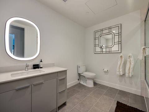 Step into your sleek, modern bathroom where a glowing mirror and soft towels await you after a refreshing shower.