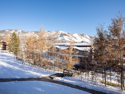 Snow-covered mountain resort with ski slopes, evergreens, and buildings nestled in a peaceful winter valley.