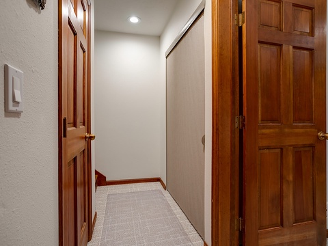 Clean hallway connects you to bedrooms and bathrooms, with rich wood doors and soft carpet underfoot for comfort.