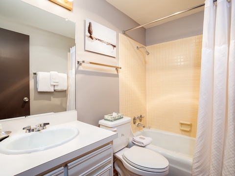 Your private bathroom features a tub-shower combo, soft towels, and warm lighting—perfect for freshening up after a day of exploring.