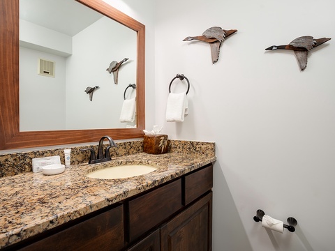 You'll love the charming rustic touches in your bathroom—elegant flying duck décor and warm wood accents create a welcoming, nature-inspired retreat with granite countertops and thoughtful amenities.