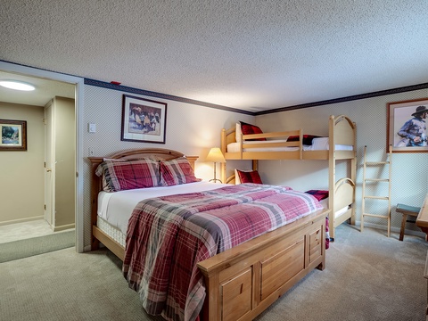 Your cozy retreat features a plush queen bed with rustic charm and a fun bunk bed, perfect for families. Warm Western art and soft lighting create a welcoming mountain getaway.