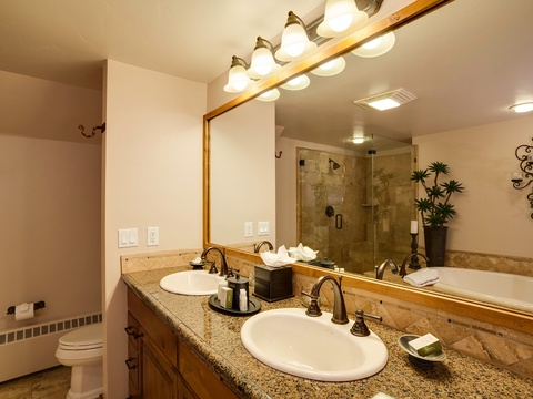 Step into your beautifully appointed bathroom with dual sinks, elegant granite countertops, soft ambient lighting, and a spacious walk-in shower that invites relaxation after a day of adventure.