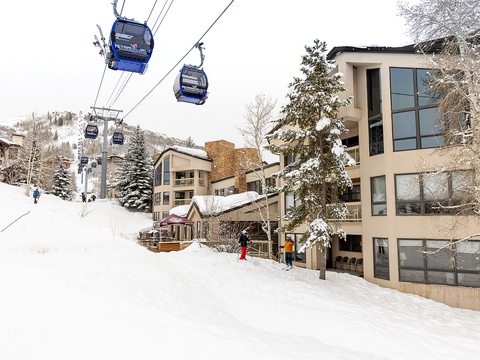 A premier ski resort village with gondola access steps from the property, surrounded by snow-covered slopes and mountain vistas.