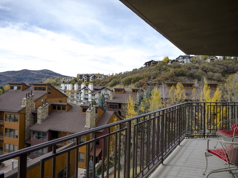 A hillside mountain resort nestled among golden autumn trees, with private balcony seating to enjoy the crisp alpine views.
