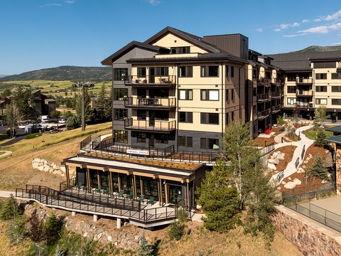 A modern multi-level property nestled in a scenic mountain valley, surrounded by rolling hills and natural landscape, offering an ideal base for exploring the area.