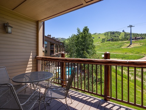 This private balcony offers a peaceful retreat where you can enjoy morning coffee or evening relaxation while taking in sweeping views of green mountain slopes and neighboring ski resort terrain.